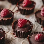Dark chocolate raspberry cups arranged in rows with vibrant berries