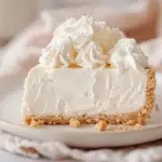 Side view of no-bake marshmallow cheesecake topped with whipped cream