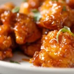 Close-up of sticky glazed 3 Ingredient Orange Chicken garnished with scallions.