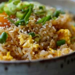 Bang Bang Fried Rice with egg yolk and scallions in a ceramic bowl