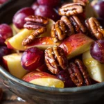 Bowl of Cinnamon Apple Grape Salad topped with honey and nuts