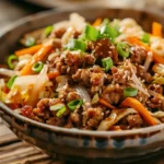 egg roll in a bowl with ground meat, cabbage, carrots, and sesame seeds