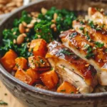 maple dijon chicken bowl topped with kale, pine nuts, and roasted vegetables