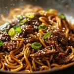 Korean beef noodles topped with sesame seeds and scallions